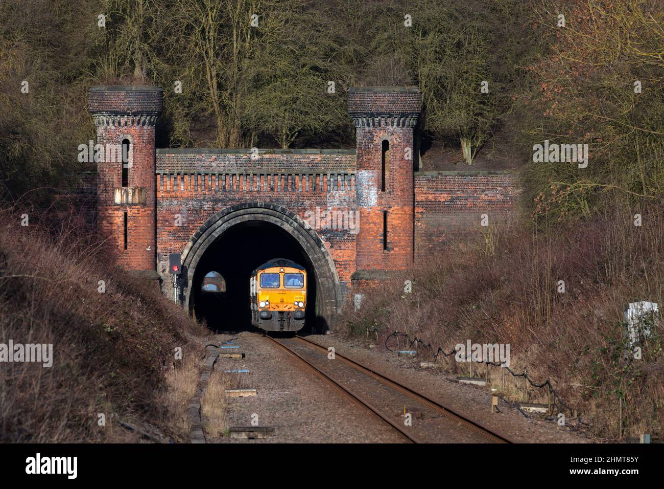 2 GB Railnight classe 66 locomotive lasciando il tunnel ornato Kirton Lindsey sulla linea Brigg, Lincolnshire, mentre gira un motore leggero Foto Stock