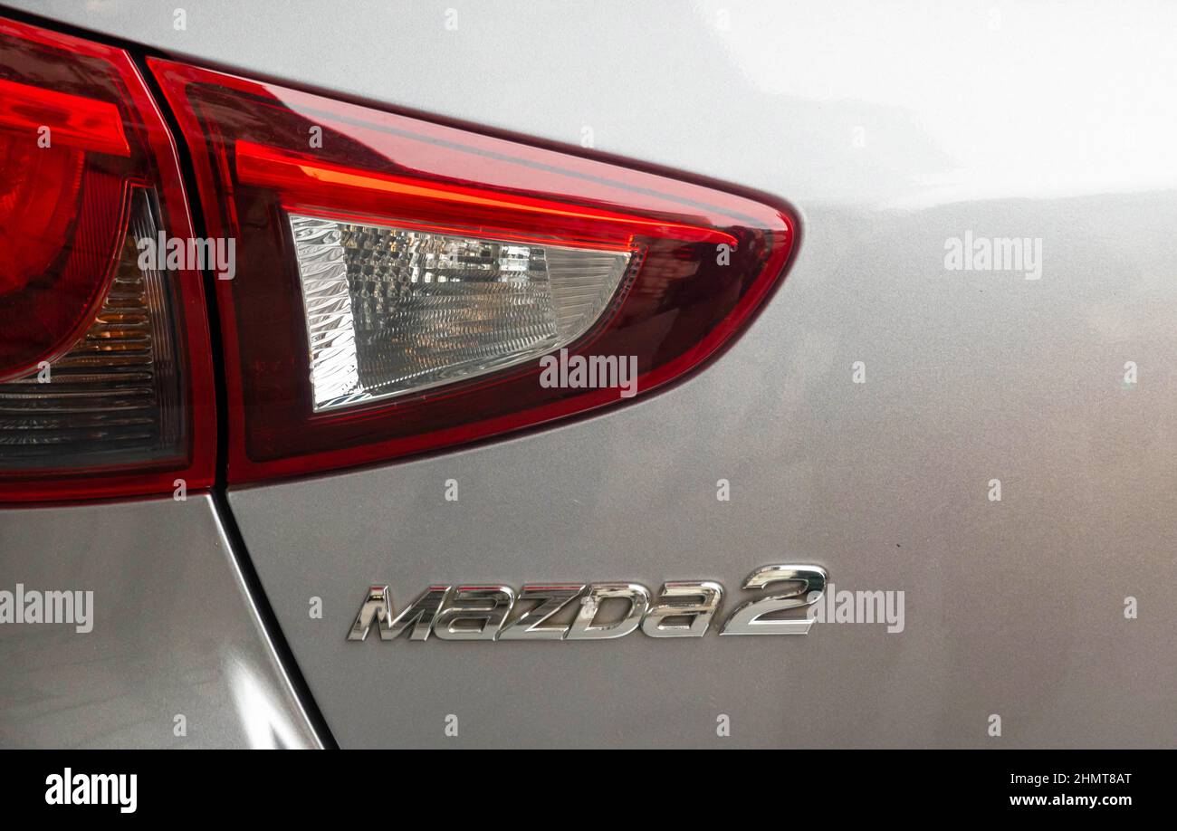La luce di posizione posteriore e la targa del nome sul bagagliaio di un auto Mazda2 Foto Stock