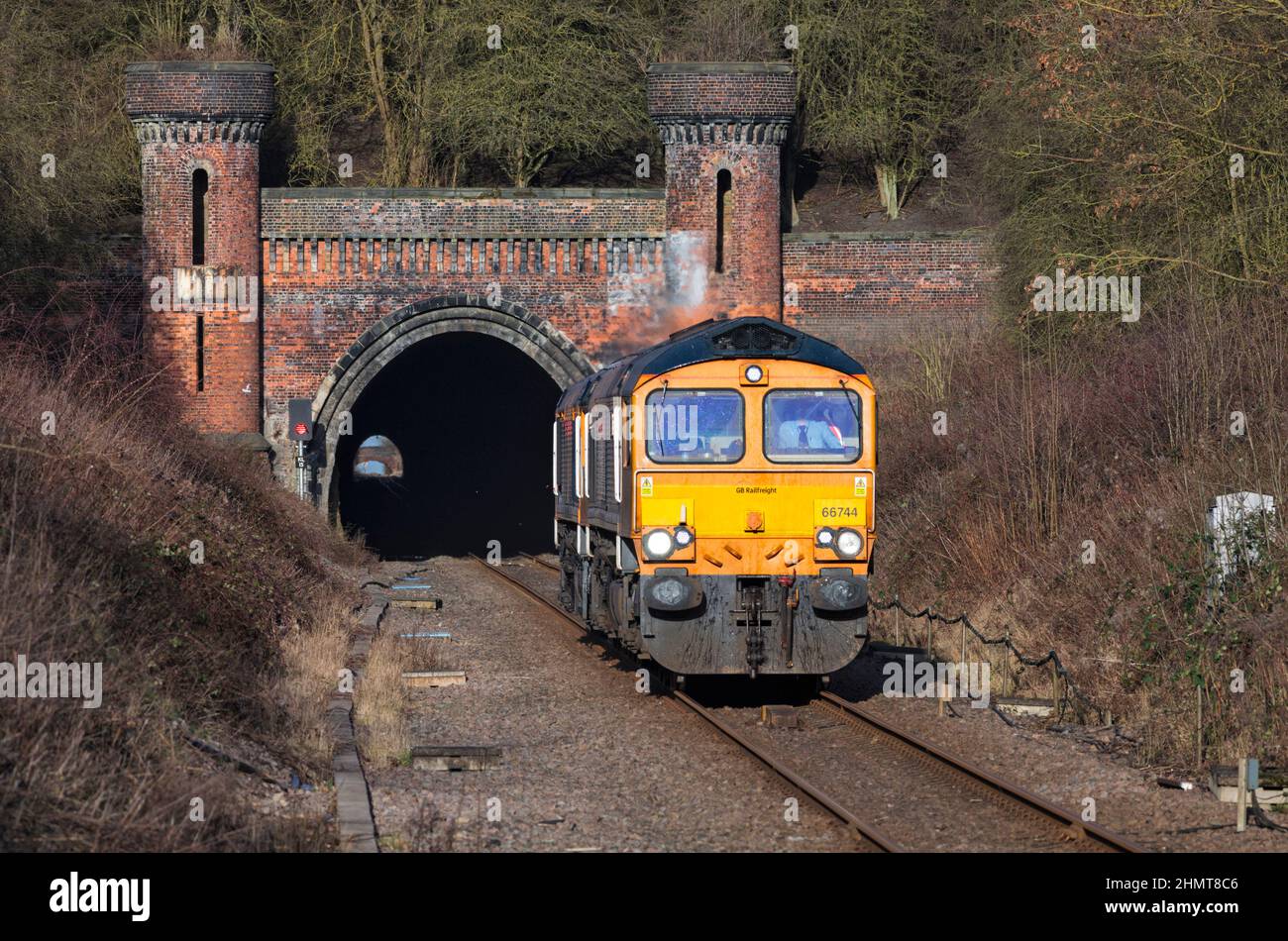 2 GB Railnight classe 66 locomotive lasciando il tunnel ornato Kirton Lindsey sulla linea Brigg, Lincolnshire, mentre gira un motore leggero Foto Stock
