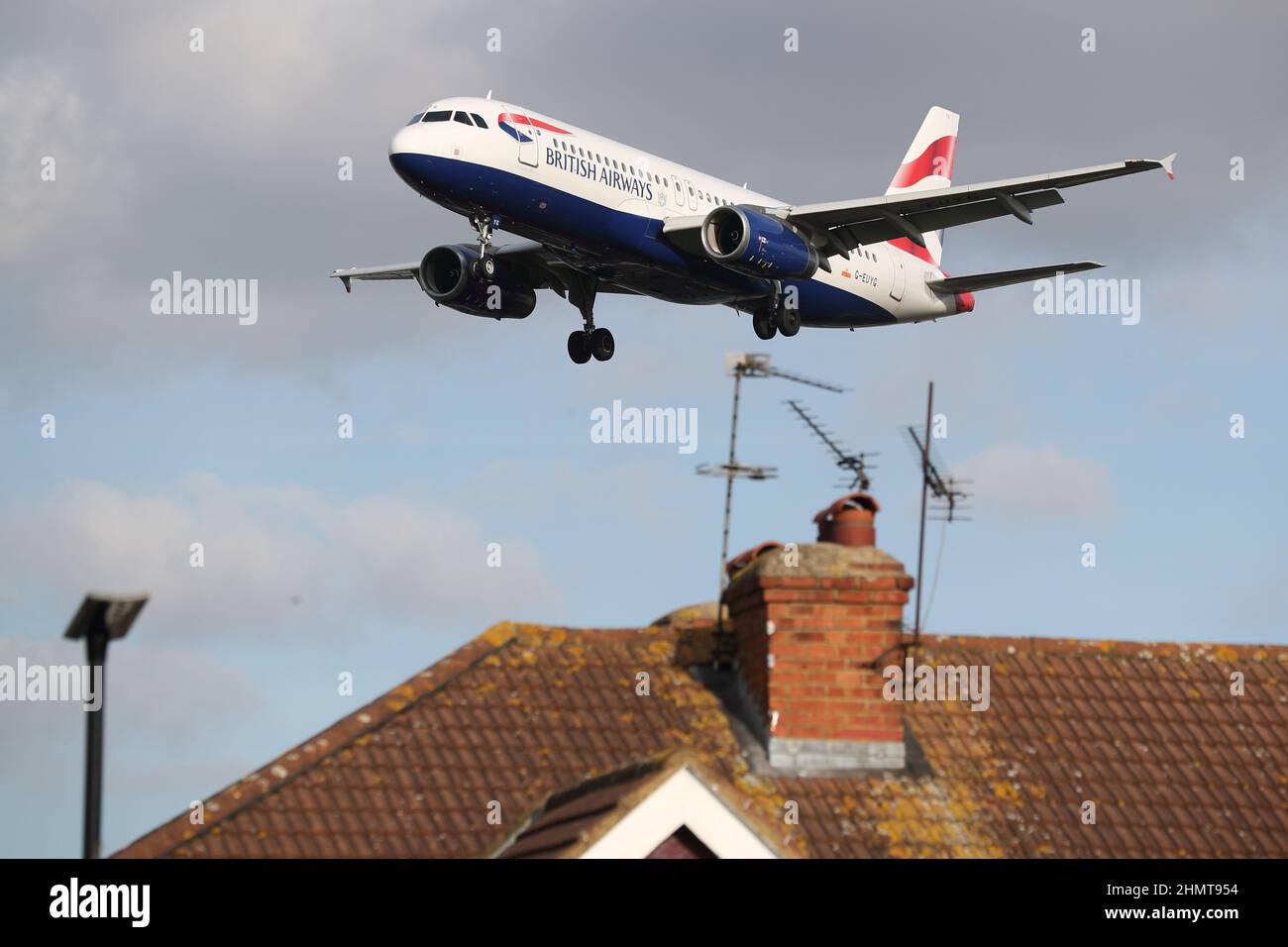 Un Airbus A320 della British Airways si avvicina all'aeroporto di Heathrow volando basso sopra i tetti delle case in Myrtle Avenue, Londra, Regno Unito Foto Stock