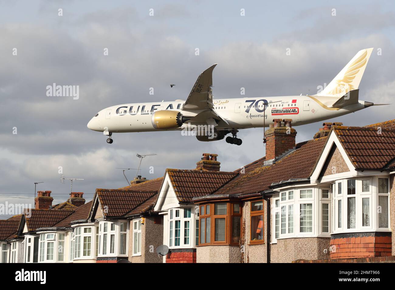 Un velivolo Gulf Air si avvicina all'aeroporto di Heathrow volando in basso sopra i tetti delle case in Myrtle Avenue, Londra, Regno Unito Foto Stock