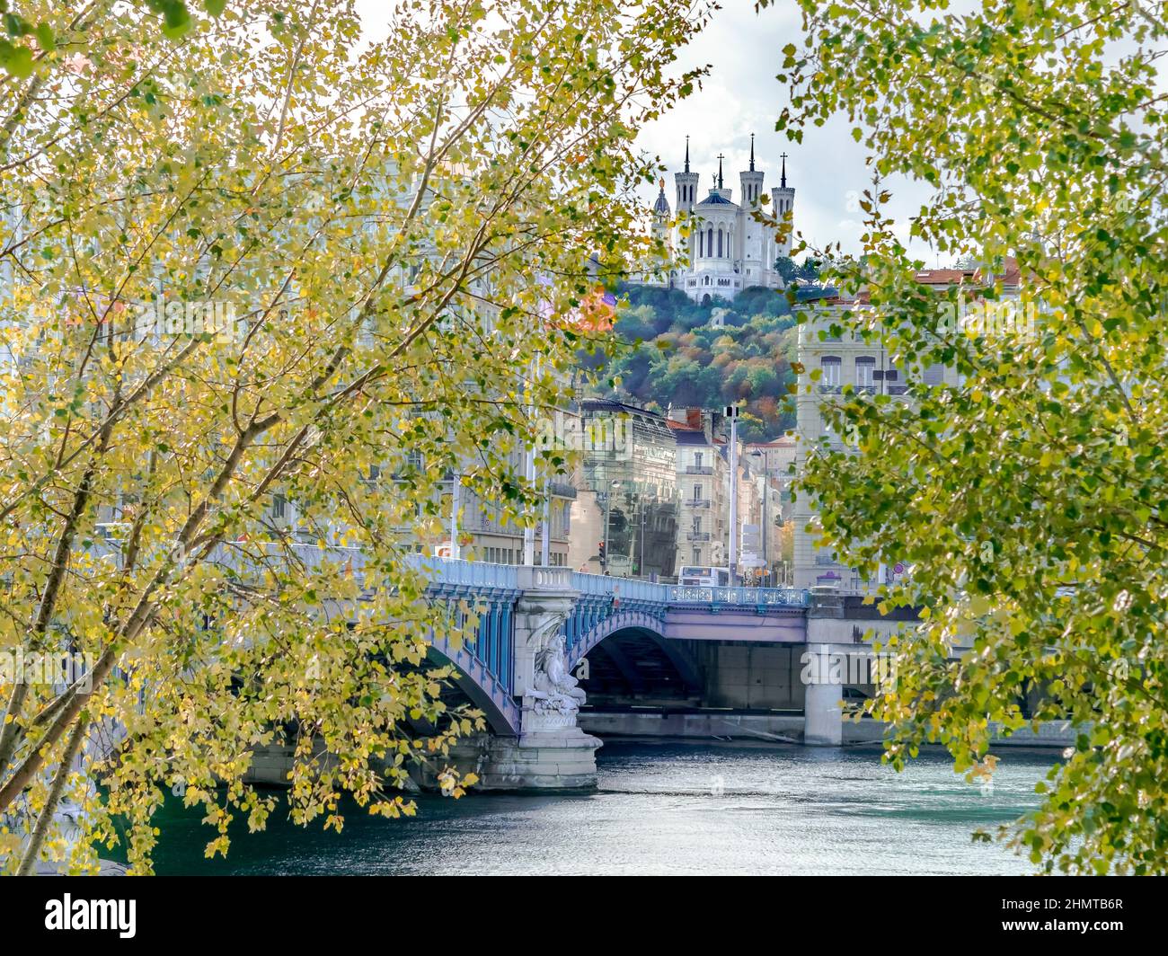 Basilica di Notre dame de fourvière, ponte Lafayette, il fiume Rodano e il parco degli hauteurs. Vista da Quai du Général Sarrail tra foglie di albero. Foto Stock