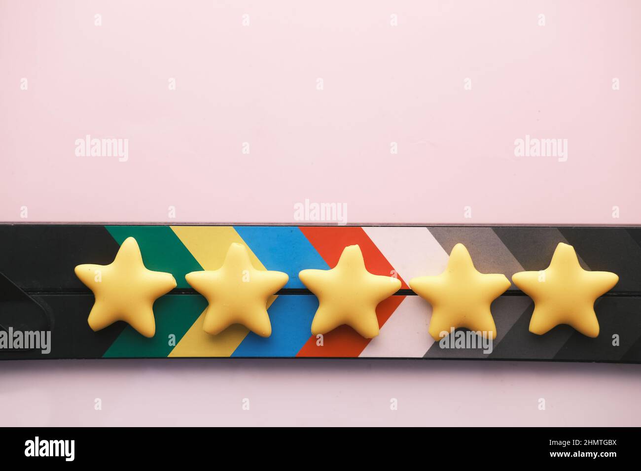 Stelle dorate e scheda clapper film su sfondo a colori Foto Stock