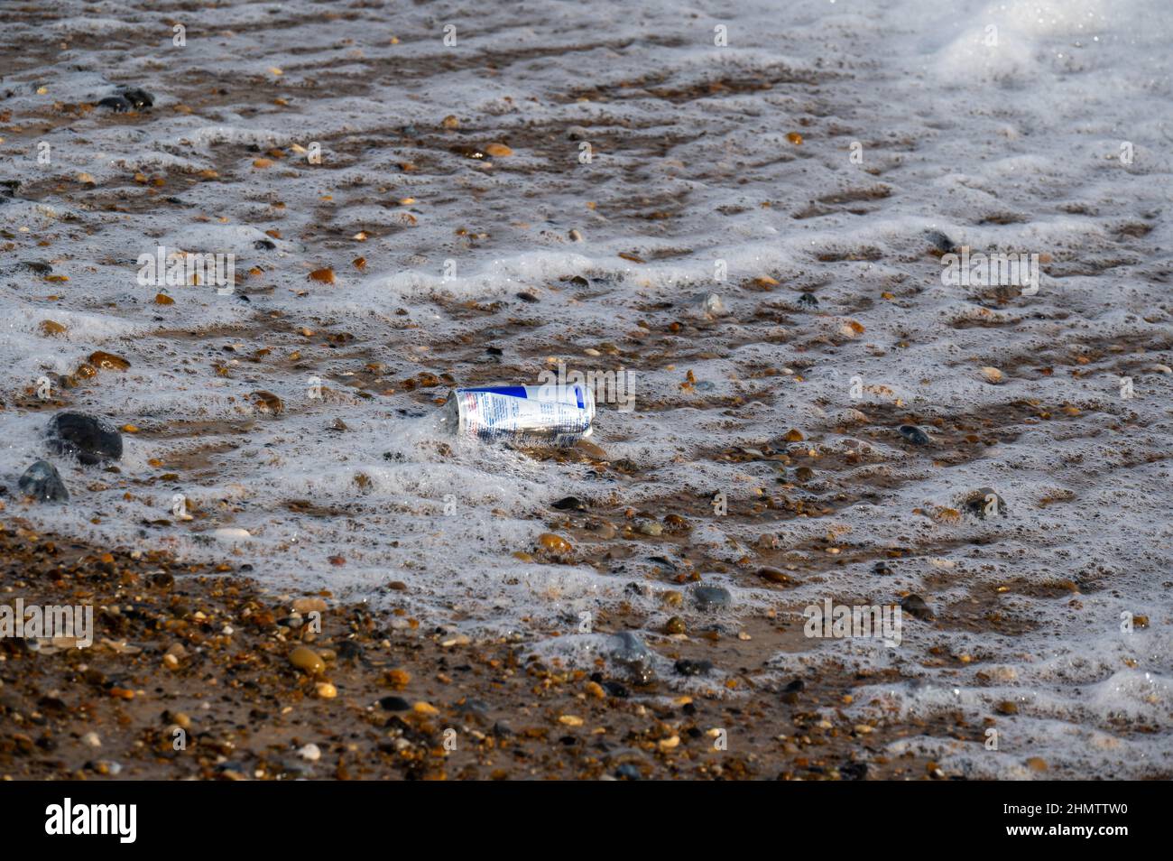 Gettato usato lattina di bevanda energetica lavato su una spiaggia sabbiosa di Norfolk Foto Stock