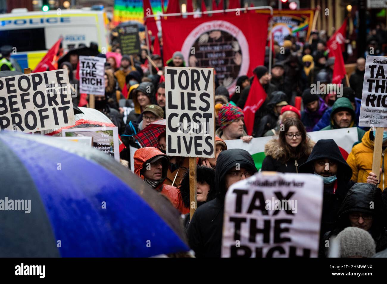 Manchester, Regno Unito. 12th Feb 2022. I manifestanti con cartelloni marciano attraverso la città. Centinaia di persone scendono in piazza per protestare contro l'aumento dei costi di vita. Organizzato dall'Assemblea dei popoli, sotto lo slogan, non possiamo pagare per questa crisi, vede manifestazioni in tutto il paese contro le Torys e la loro gestione della situazione attuale e sempre in peggioramento in cui si trovano migliaia di persone. Credit: Andy Barton/Alamy Live News Foto Stock