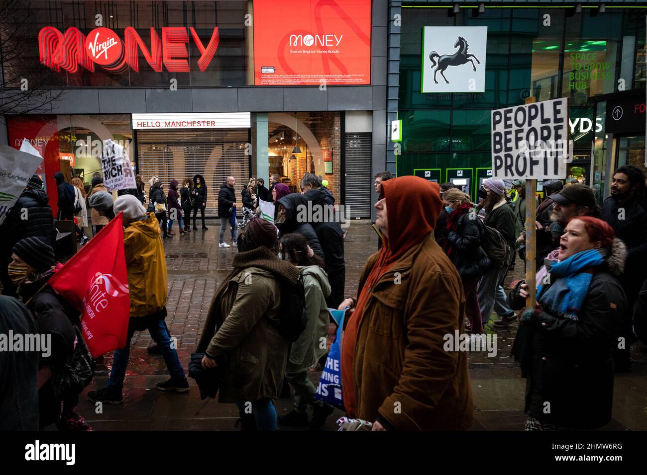 Manchester, Regno Unito. 12th Feb 2022. I manifestanti con cartelloni marciano attraverso la città. Centinaia di persone scendono in piazza per protestare contro l'aumento dei costi di vita. Organizzato dall'Assemblea dei popoli, sotto lo slogan, non possiamo pagare per questa crisi, vede manifestazioni in tutto il paese contro le Torys e la loro gestione della situazione attuale e sempre in peggioramento in cui si trovano migliaia di persone. Credit: Andy Barton/Alamy Live News Foto Stock