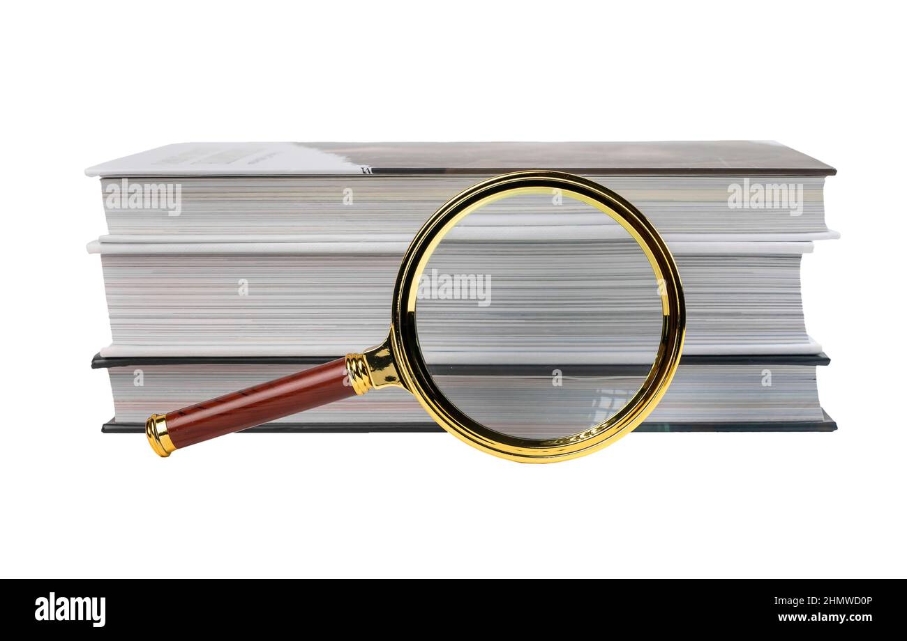 I libri impilano e lente d'ingrandimento isolato su sfondo bianco. Ricerca e analisi delle informazioni. Foto di alta qualità Foto Stock
