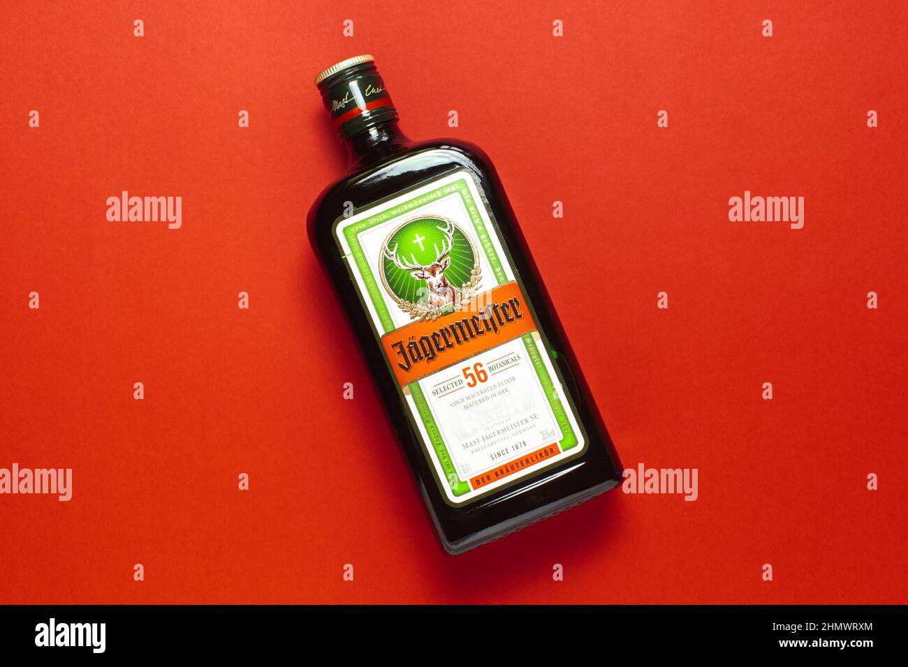 Ternopil, Ucraina - 24 maggio 2021: Una bottiglia di liquore Jagermeister su sfondo rosso vista dall'alto Foto Stock