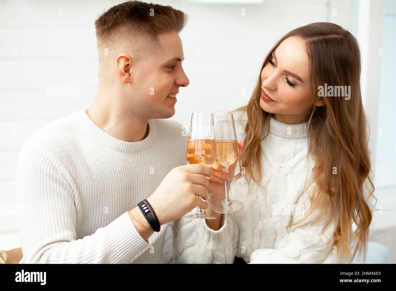 Giovani persone belle bere vino da bicchieri di vetro celebrare la conoscenza. Amore a prima vista. Relazioni romantiche. Amore e tenerezza Foto Stock
