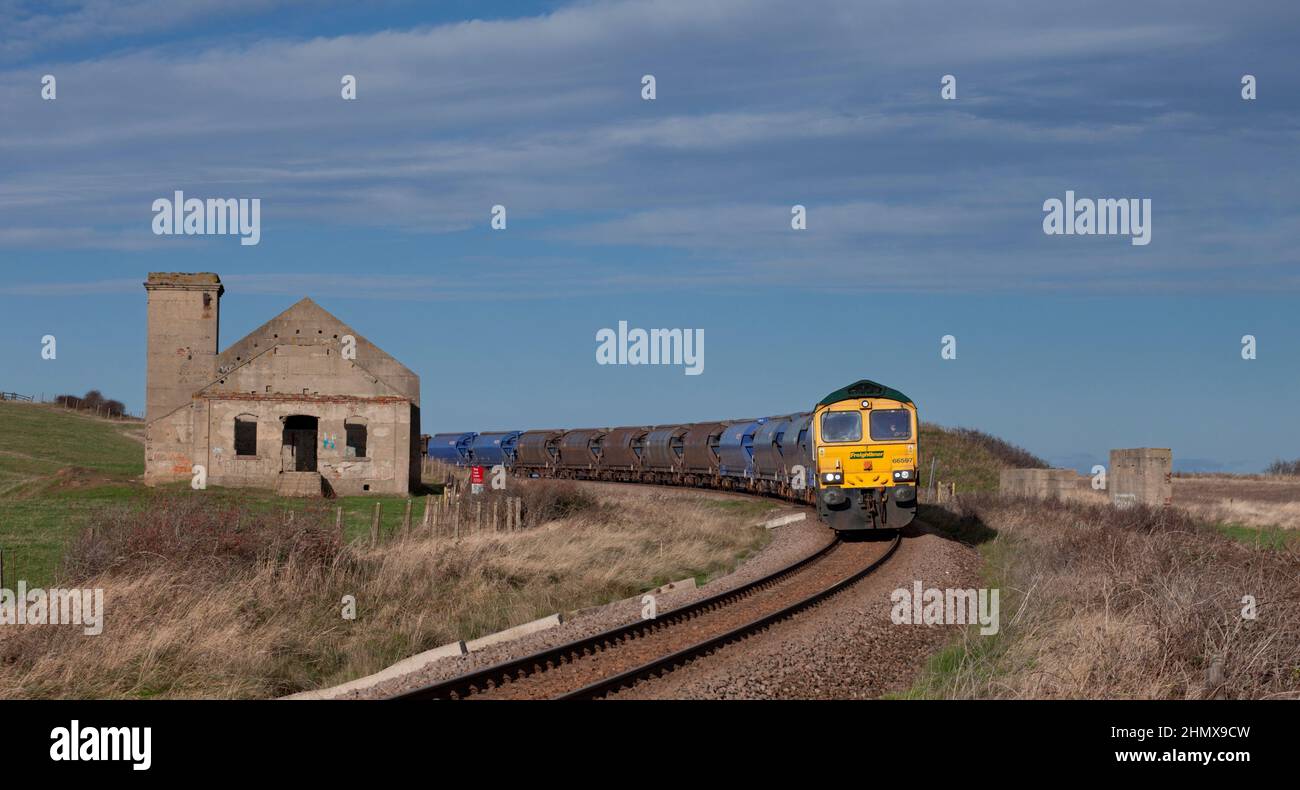 Locomotiva Freightliner classe 66 sulla filiale di Boulby, Teesside con un treno merci per Boulby per il carico con sale di roccia. Passando per la casa del ventilatore di Brotton Foto Stock