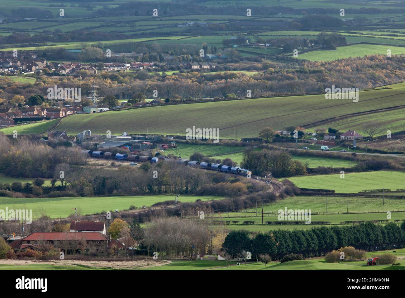 Freightliner Classe 66 il trasporto di un treno che trasporta il potash dalla miniera di Boulby al molo dei Tees passa Crag Hall sulla linea solo merci a Boubly Foto Stock