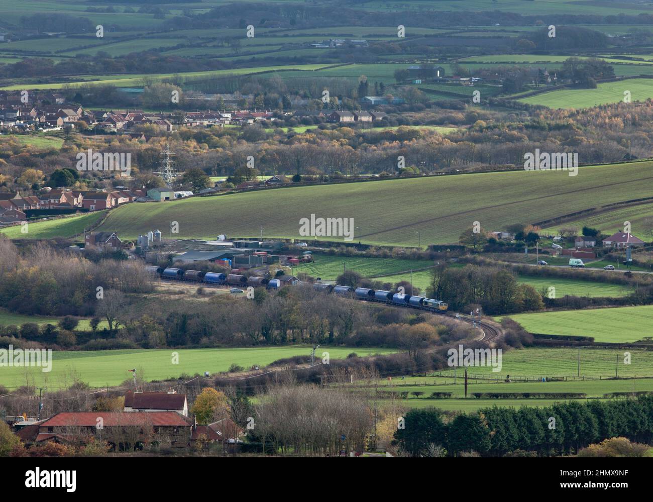 Freightliner Classe 66 il trasporto di un treno che trasporta il potash dalla miniera di Boulby al molo dei Tees passa Crag Hall sulla linea solo merci a Boubly Foto Stock
