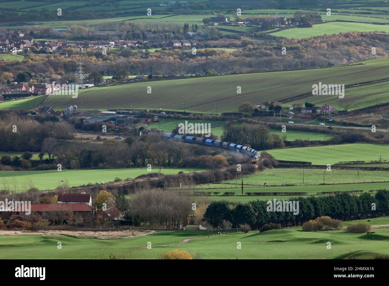 Freightliner Classe 66 il trasporto di un treno che trasporta il potash dalla miniera di Boulby al molo dei Tees passa Crag Hall sulla linea solo merci a Boubly Foto Stock