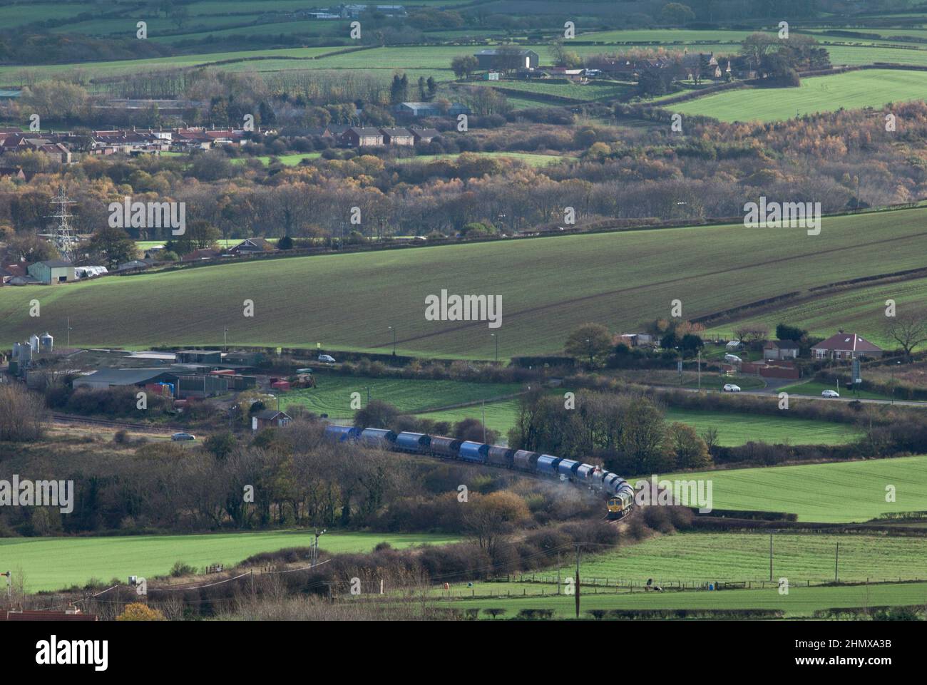Freightliner Classe 66 il trasporto di un treno che trasporta il potash dalla miniera di Boulby al molo dei Tees passa Crag Hall sulla linea solo merci a Boubly Foto Stock