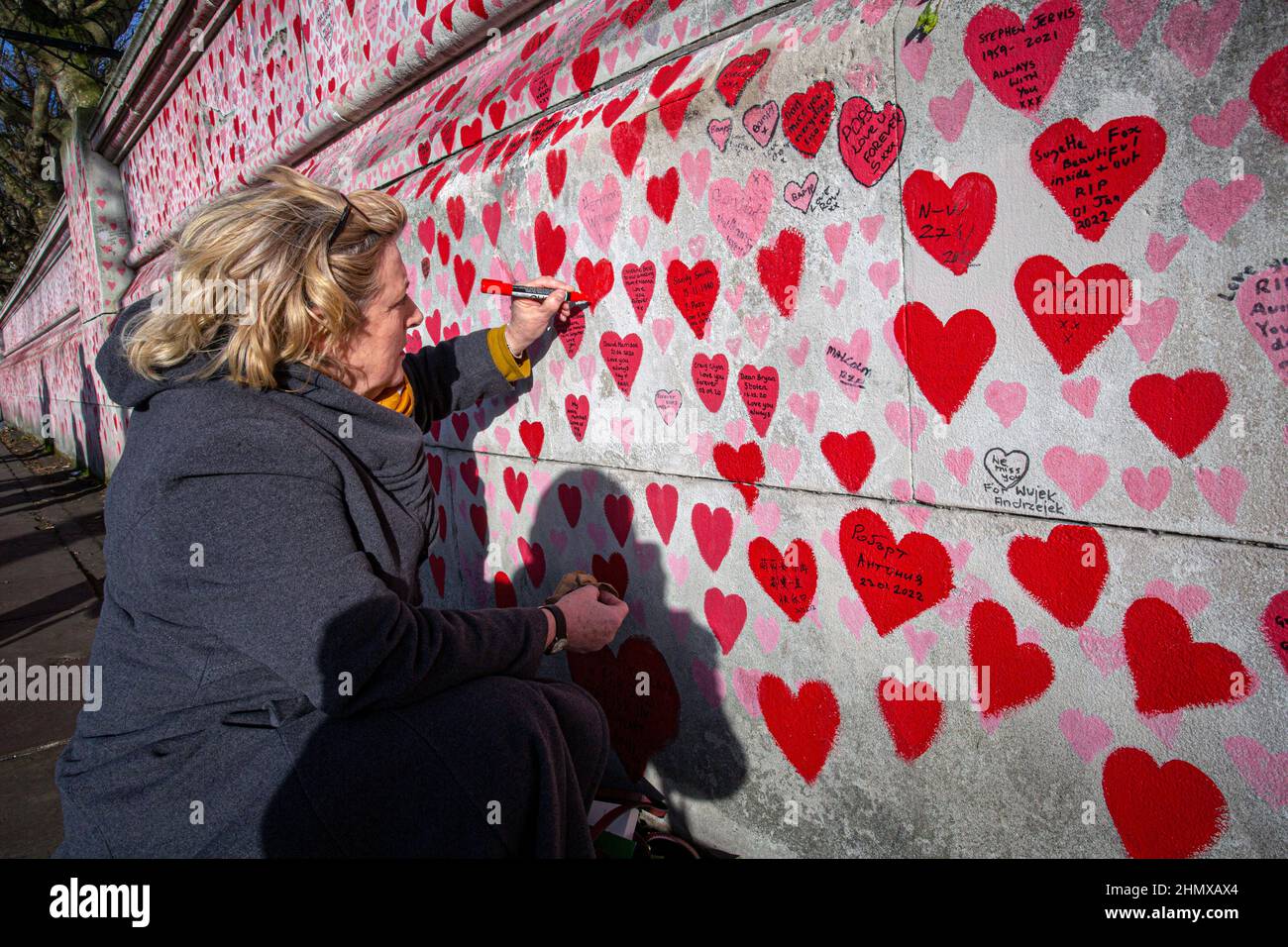 I nomi di scrittura femminile sul National COVID Memorial Wall dipinto con cuori rossi in bella giornata di sole . Westminster, Londra , Regno Unito . Foto Stock