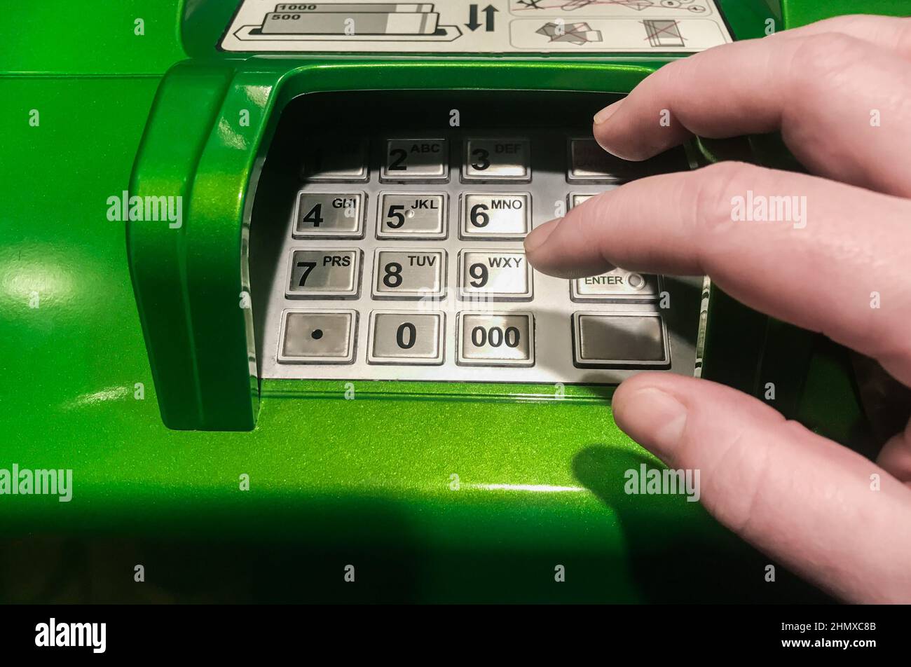 Primo piano di un bancomat. La mano sta per premere ATM EPP tastiera. Foto Stock