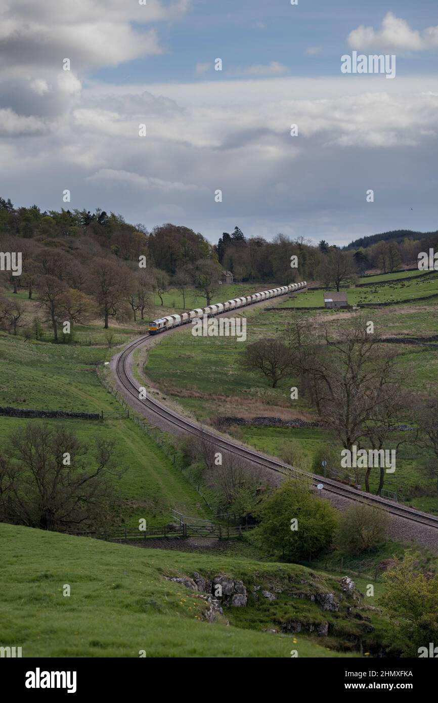 Una locomotiva GB Railnight classe 66 66738 che trasporta un treno di tramogge di aggregati vuoti sulla linea di diramazione di trasporto Rylstone vicino a Skipton, Yorkshire Foto Stock