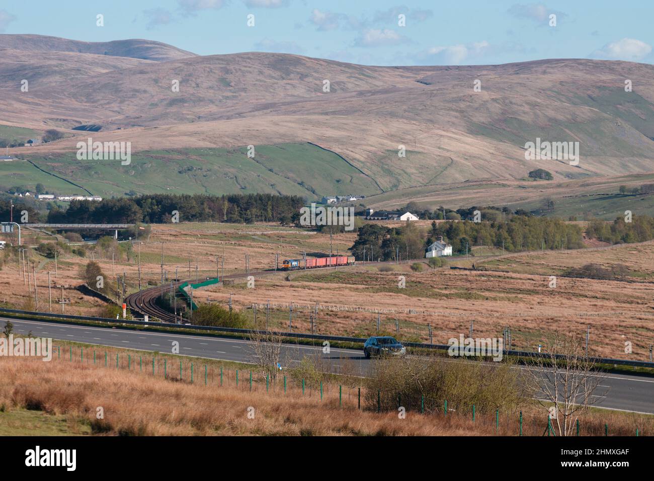 GB Railnight classe 66 locomotiva 66709 sulla linea principale della costa occidentale nella campagna della Cumbria passando Scout Green con un treno di negozi dell'esercito Foto Stock