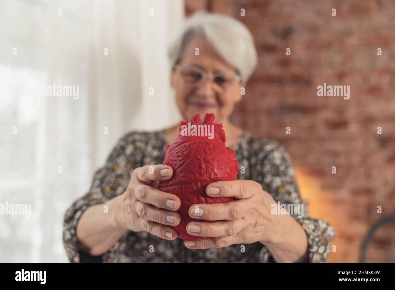 nonna caucasica che ricorda di esaminare le malattie cardiache e prendersi cura della salute. Foto di alta qualità Foto Stock