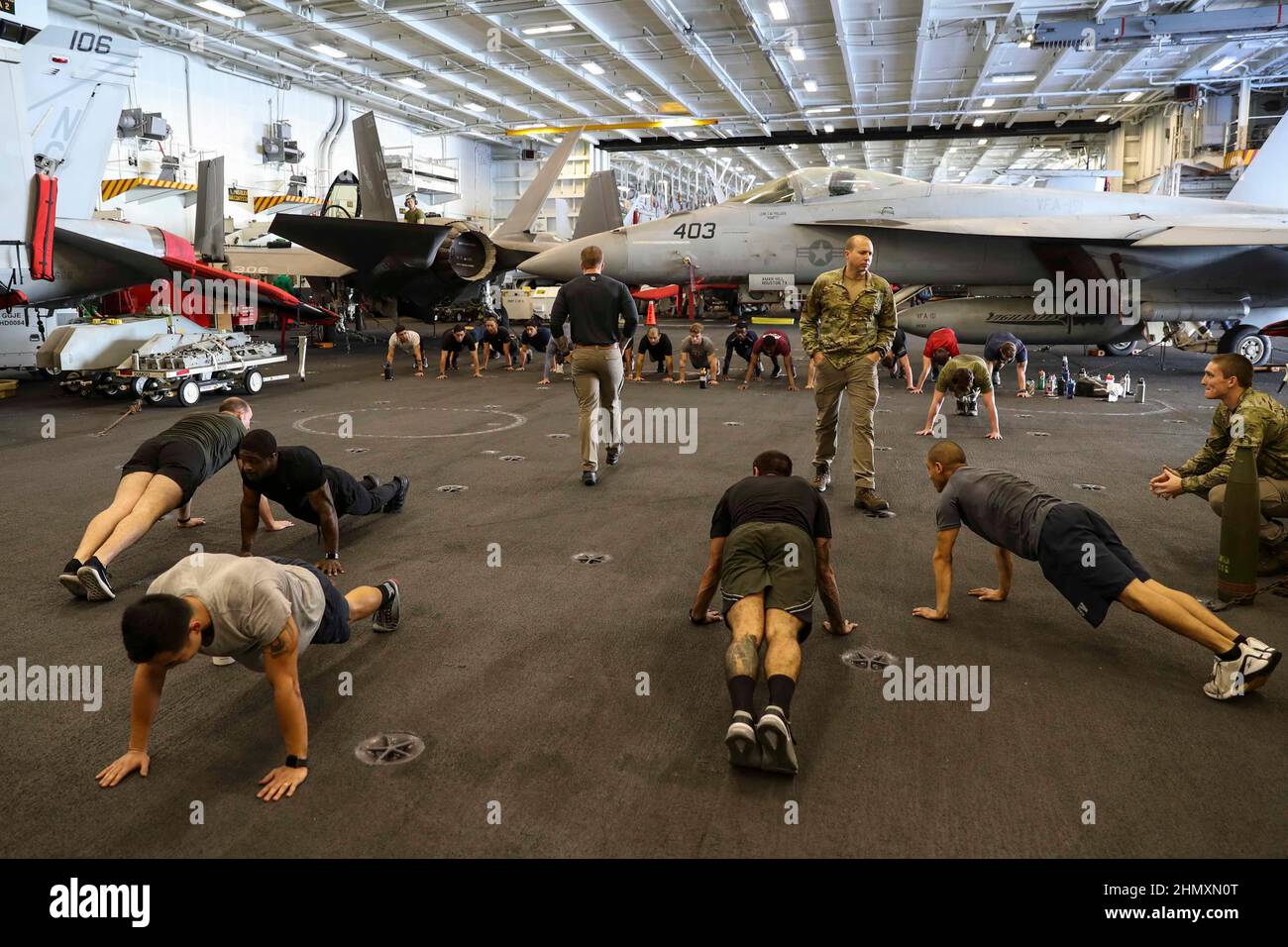 MAR DELLE FILIPPINE (Feb 12, 2022) i marinai partecipano all'addestramento incrociato di Explosive Ordnance Disposal (EOD) nella baia di hangar a bordo della portaerei di classe Nimitz USS Abraham Lincoln (CVN 72). Abraham Lincoln Strike Group è in fase di implementazione pianificata nell'area delle operazioni della flotta USA 7th per migliorare l'interoperabilità attraverso alleanze e partnership, fungendo da forza di risposta pronta a supportare una regione indopacifica libera e aperta. (STATI UNITI Foto Navy di Mass Communication Specialist 3rd Classe Madison Cassidy) Foto Stock