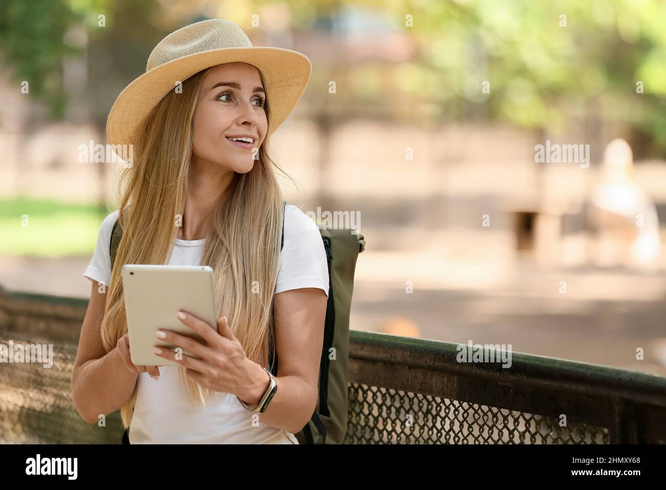 Turista femminile con computer tablet in giardino zoologico Foto Stock