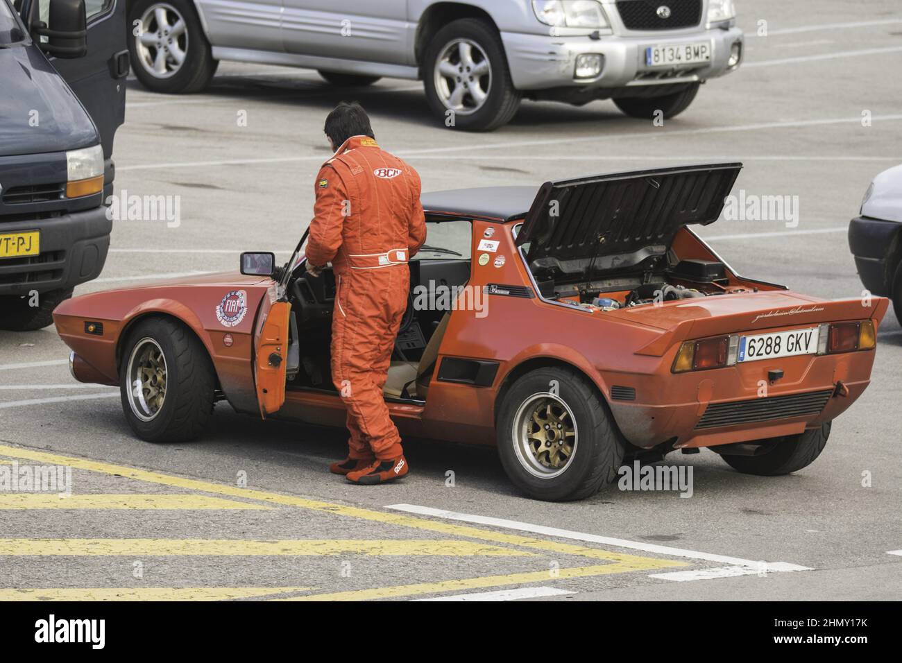 Foto di un pilota vicino ad una Fiat Bertone X1 9 di colore rosso in pista, una rara auto Foto Stock