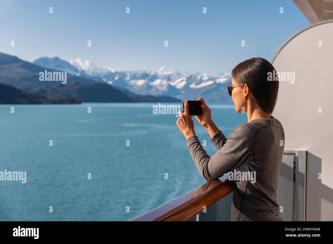 Alaska nave da crociera passeggero fotografando il paesaggio stupefacente che entra nel Glacier Bay National Park, Stati Uniti. Donna turistica che scatta foto con il cellulare Foto Stock