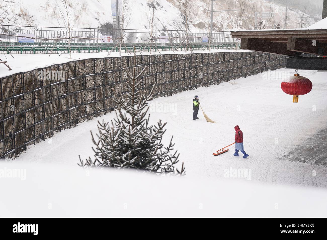 Zhangjiakou, la provincia cinese di Hebei. 13th Feb 2022. I membri dello staff puliscono la neve fuori dal Centro Stampa del Monte Zhangjiakou a Zhangjiakou, nella provincia di Hebei della Cina settentrionale, 13 febbraio 2022. Credit: Peng Ziyang/Xinhua/Alamy Live News Foto Stock