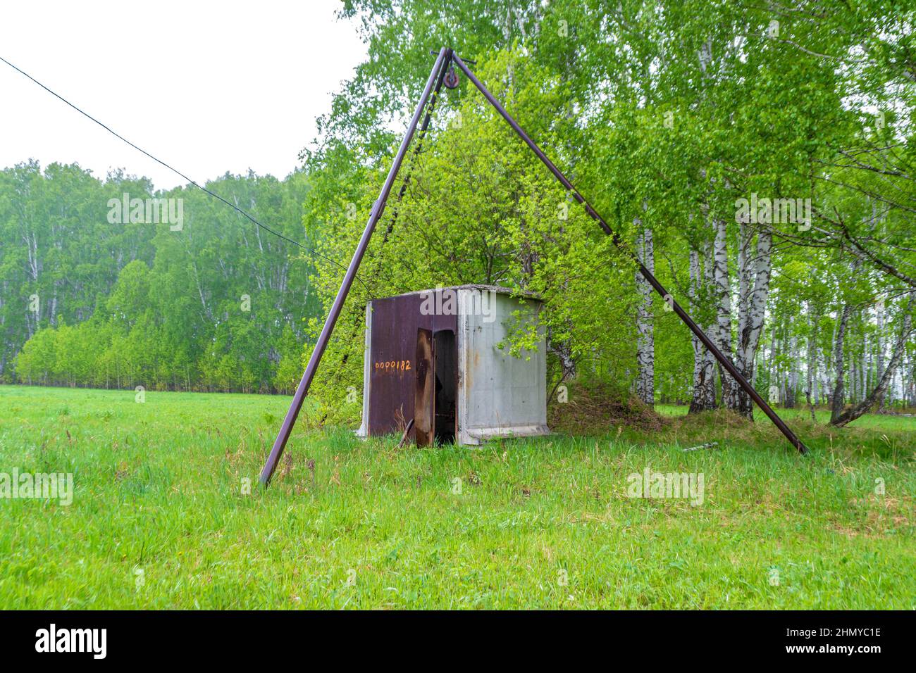 pozzo d'acqua con una stazione di pompaggio in per la produzione agricola per l'irrigazione di campi e bestiame, fuoco selettivo Foto Stock