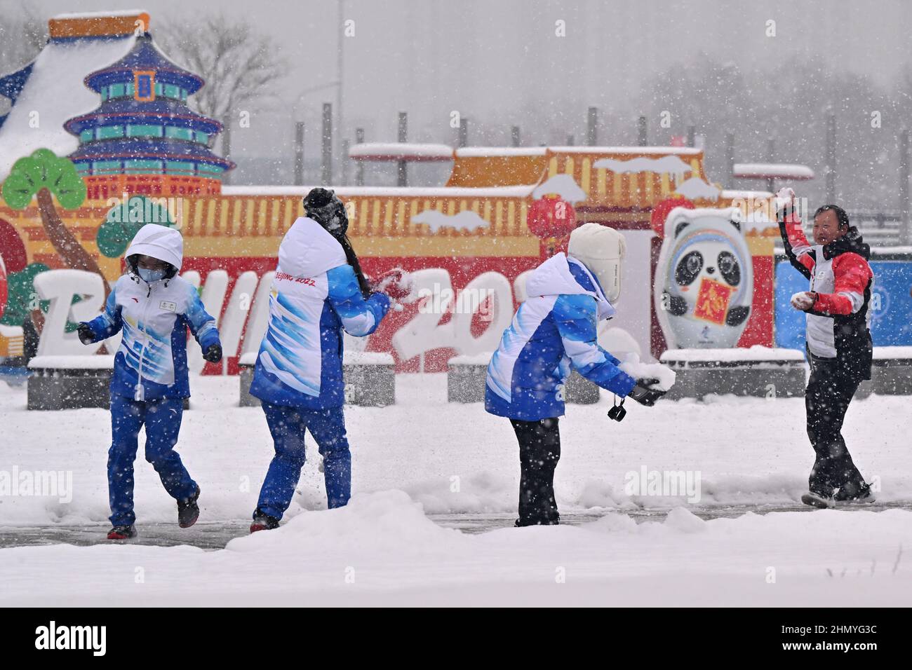 Pechino, Cina. 13th Feb 2022. Olimpiadi, caratteristica, passersby utilizzare la neve nel parco vicino al centro media delle Olimpiadi invernali di Pechino 2022 per una lotta con la palla di neve. Credit: Peter Kneffel/dpa/Alamy Live News Foto Stock