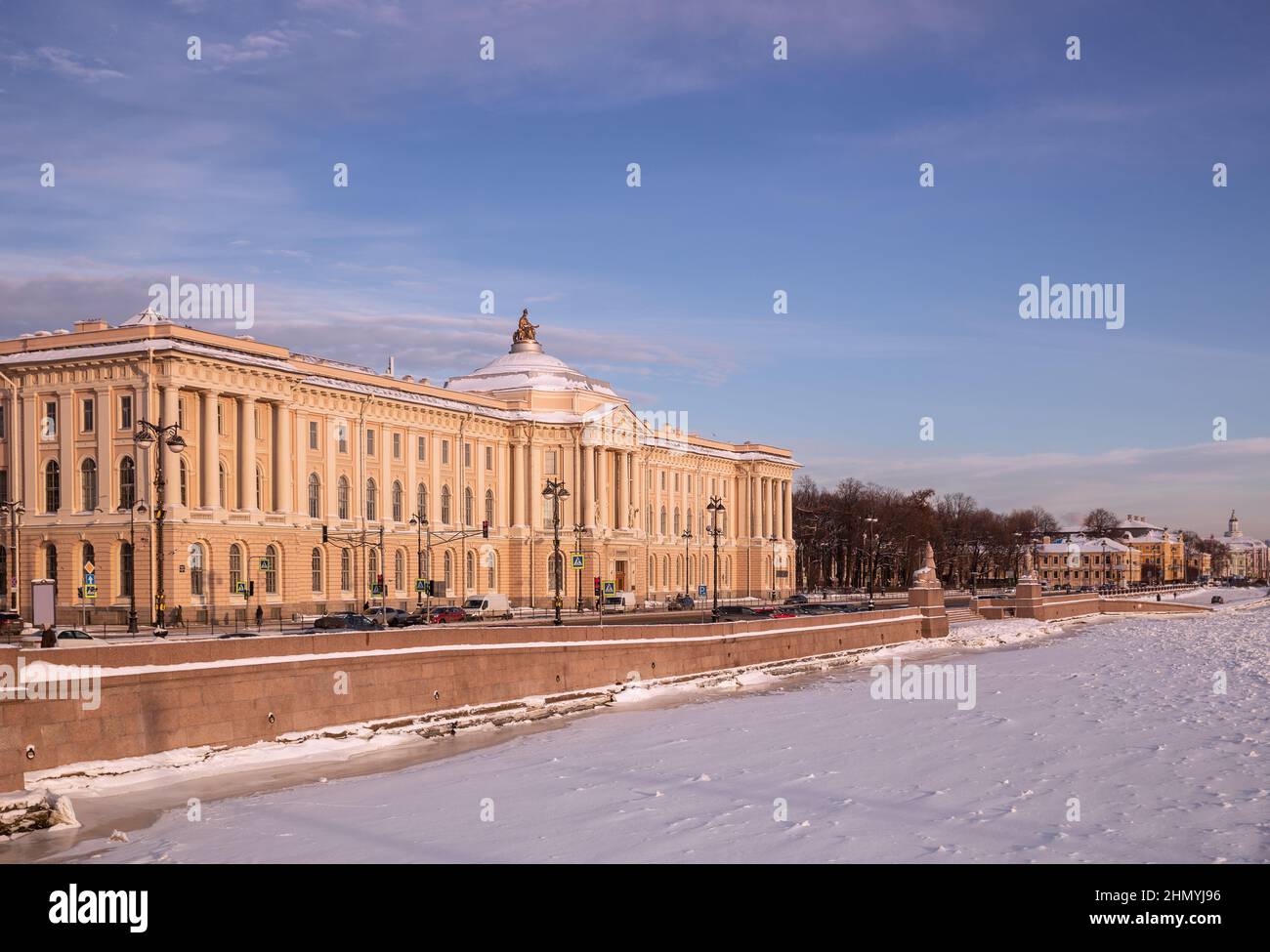 Inverno a San Pietroburgo, vista dell'Accademia delle Arti e dell'Università Embankment. Giorno di sole gelido, fiume Neva coperto di ghiaccio e neve Foto Stock