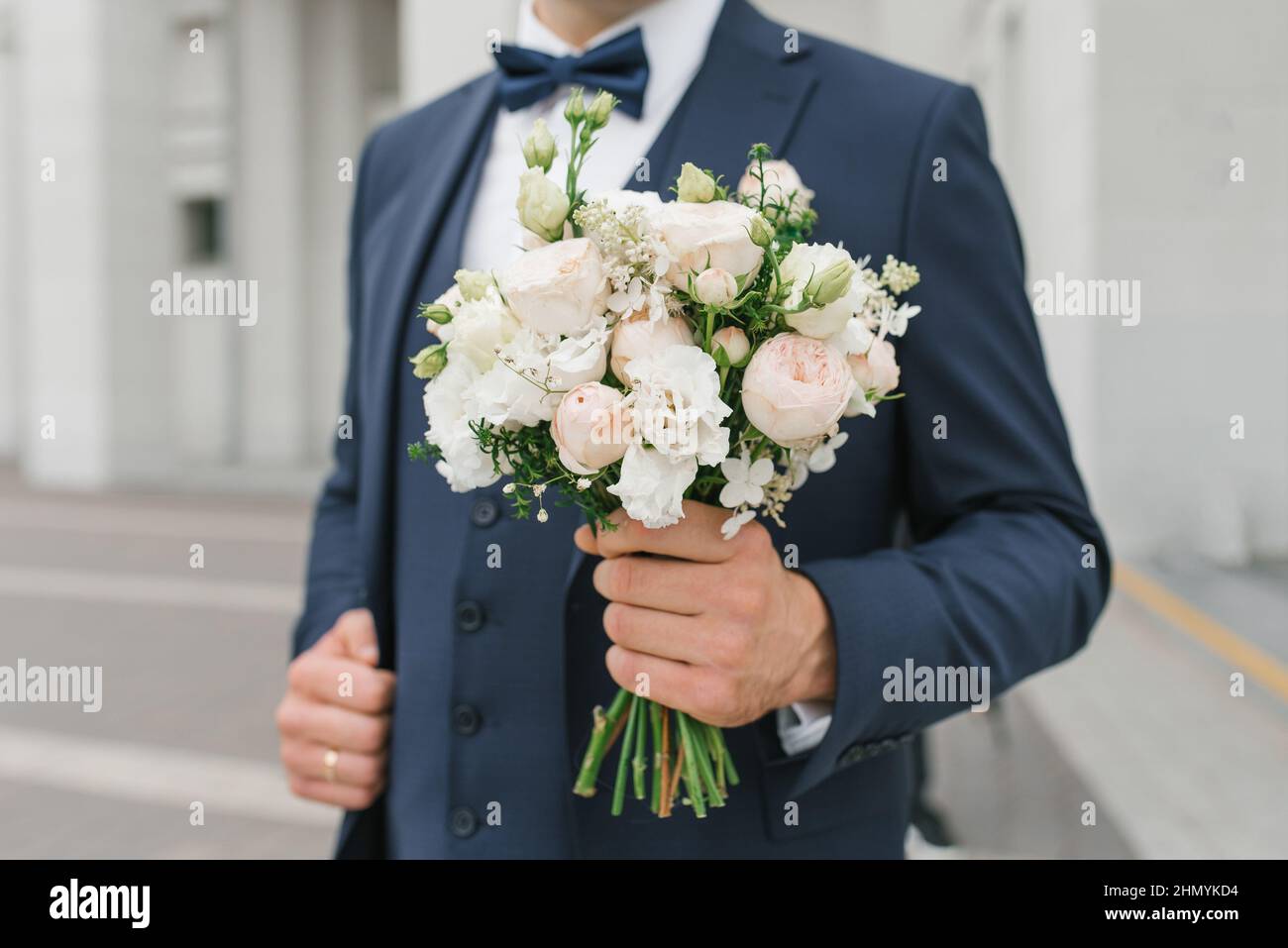 Un uomo tiene un bouquet di nozze nelle sue mani. Il concetto di San Valentino e l'amore. Concetto di matrimonio. Foto Stock