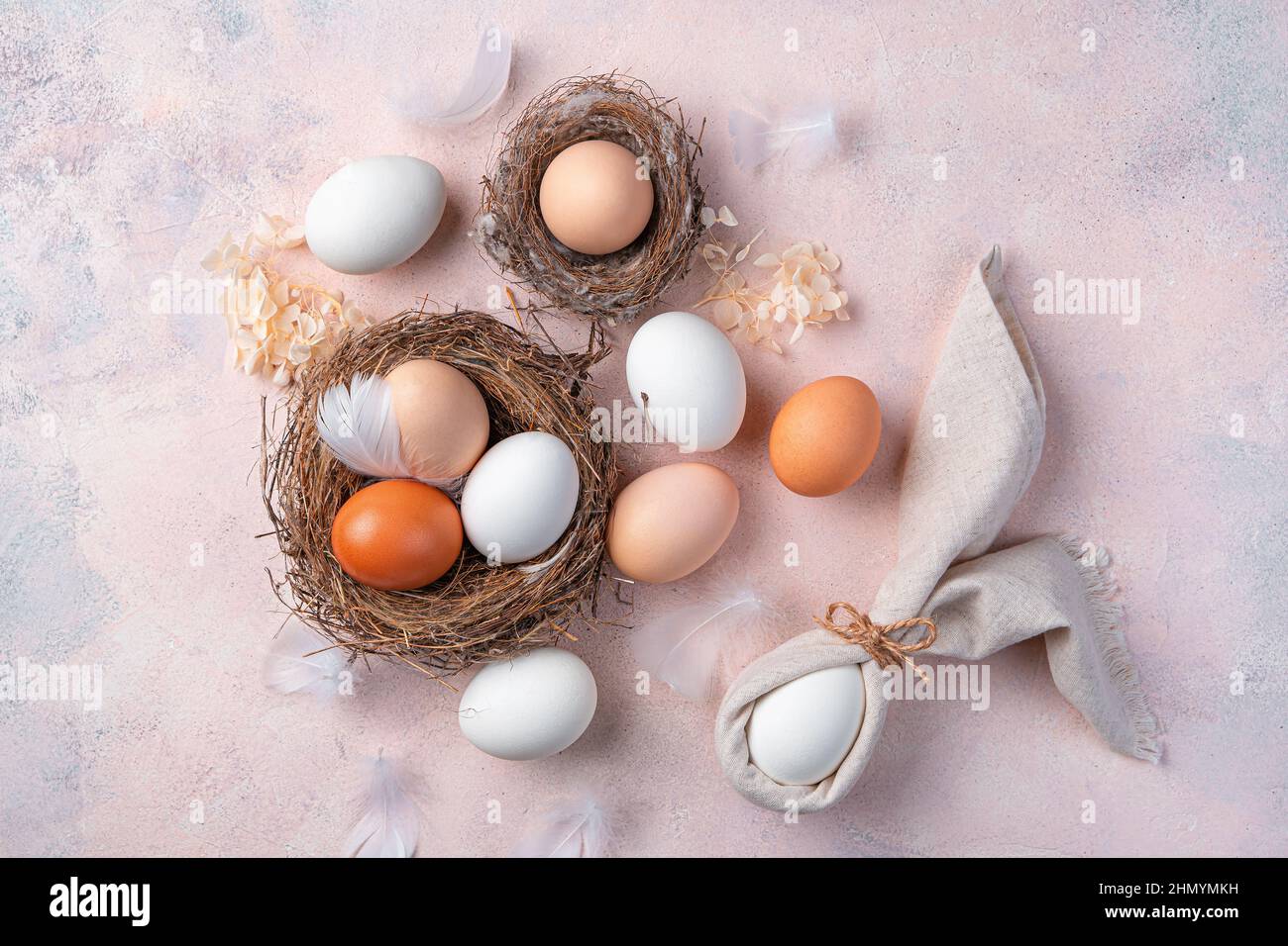 Pasqua sfondo pasquale con uova in un nido su uno sfondo chiaro. Vista dall'alto. Foto Stock