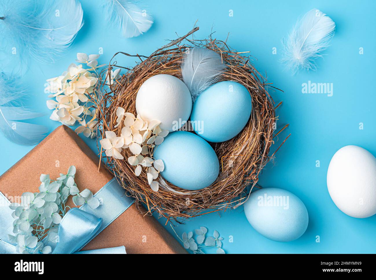 Buona Pasqua, un nido con le uova di Pasqua primo piano su uno sfondo blu. Vista dall'alto. Foto Stock