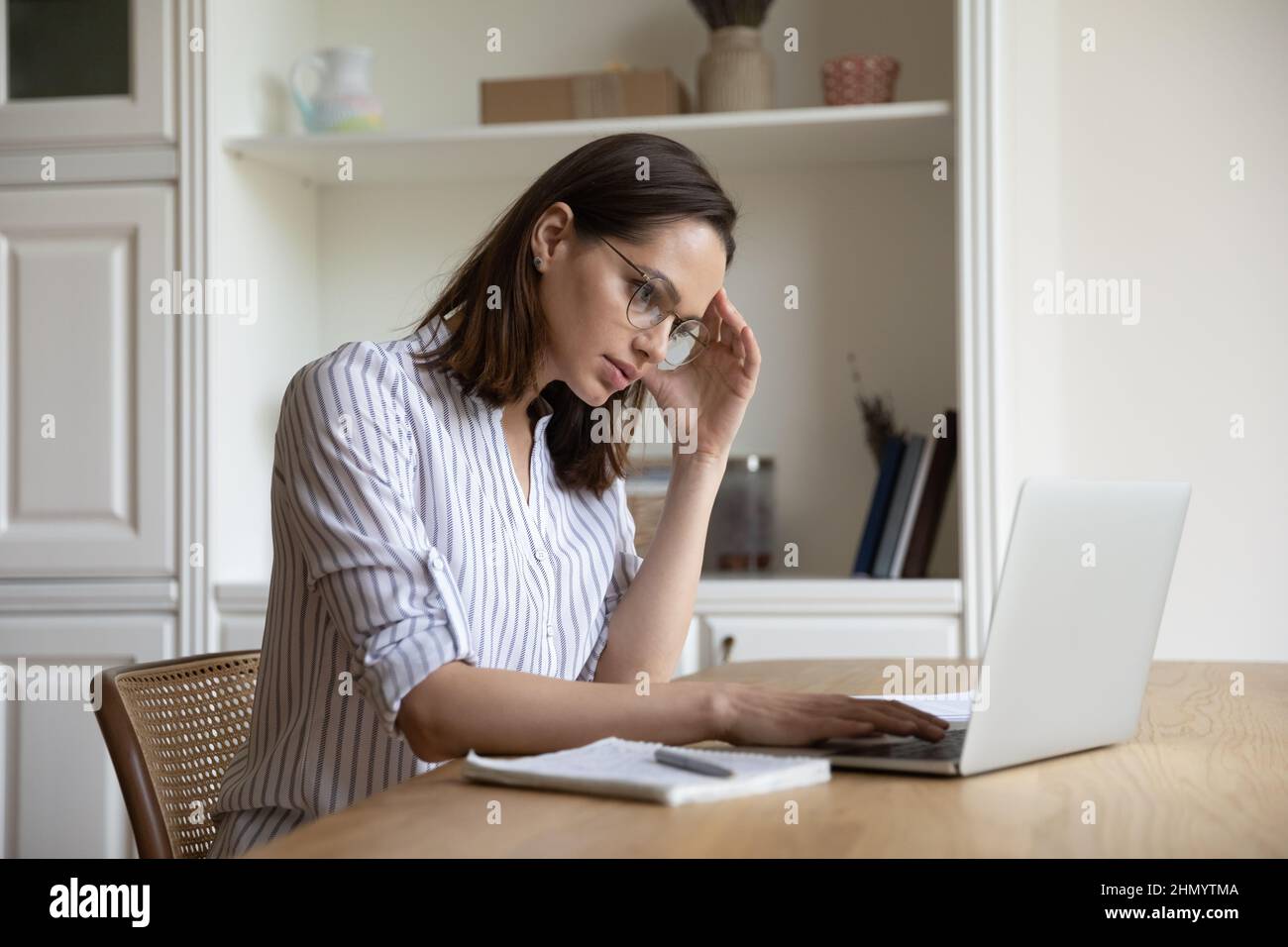 Confusa giovane donna d'affari infelice che ha problemi con un compito difficile. Foto Stock