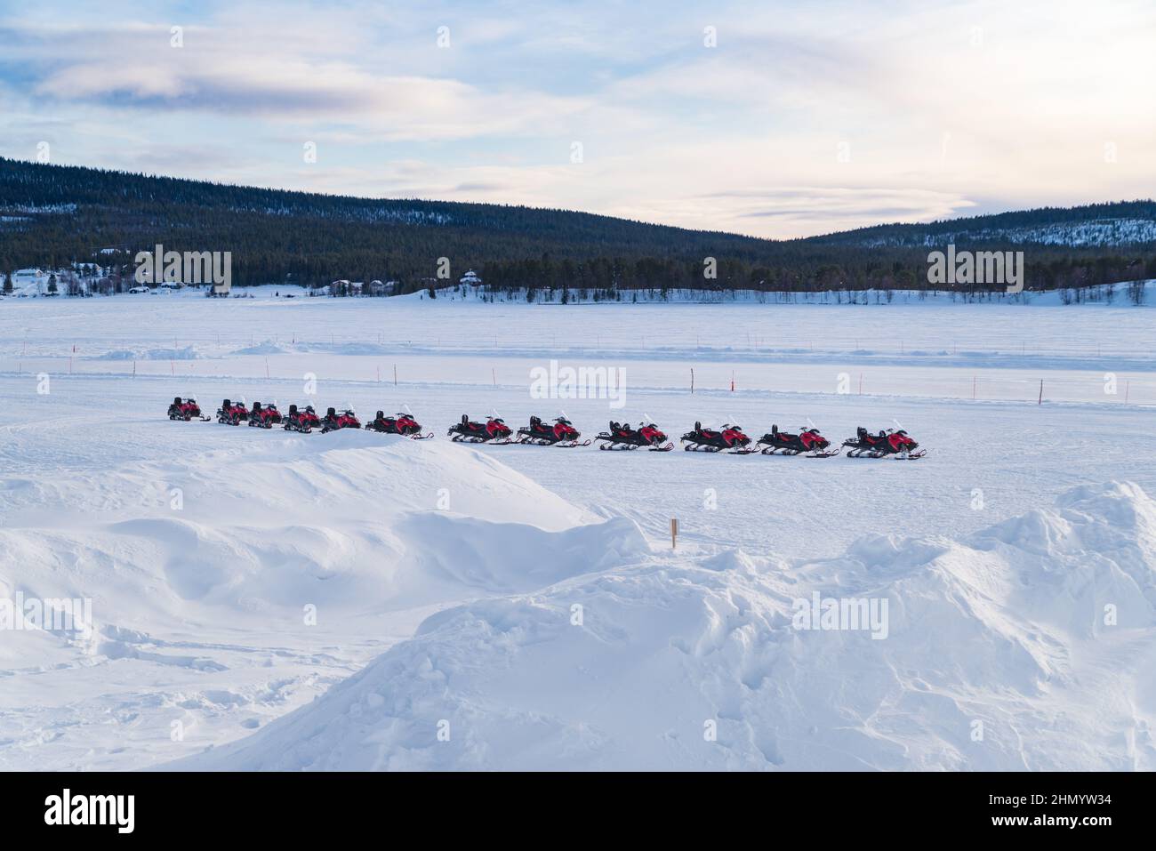 fila di motoslitte su un fiume ghiacciato in attesa di turisti Foto Stock