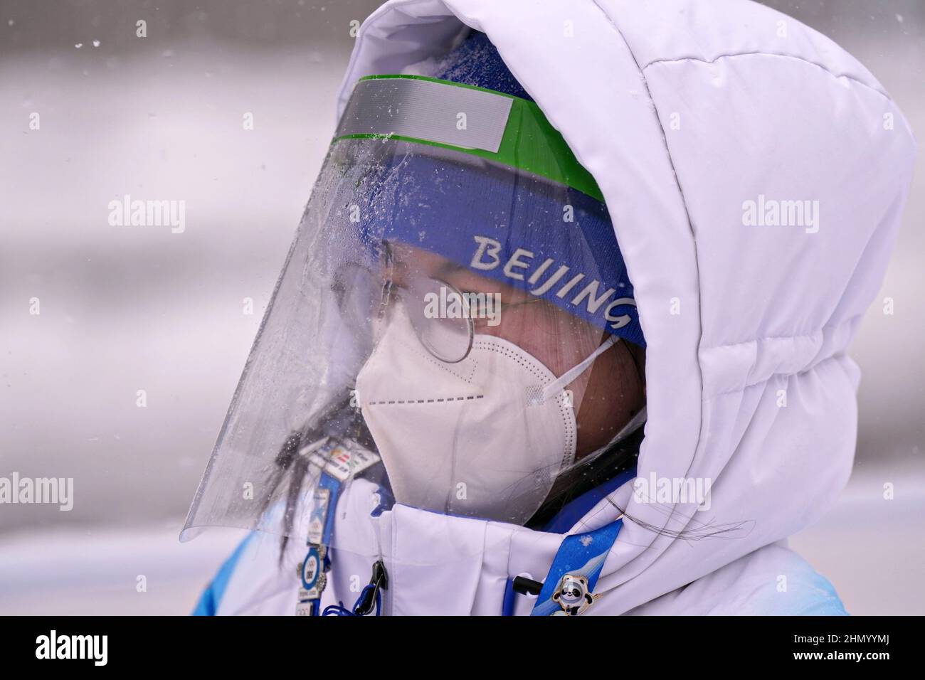 Un volontario olimpico indossa la protezione da Covid durante una nevicata pesante alle Olimpiadi invernali di Pechino 2022 di domenica 13 febbraio 2022. Foto di Richard Ellis/UPI Foto Stock