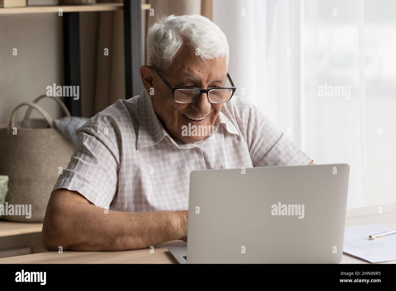 Felice anziano 80s uomo in occhiali utilizzando il portatile Foto Stock