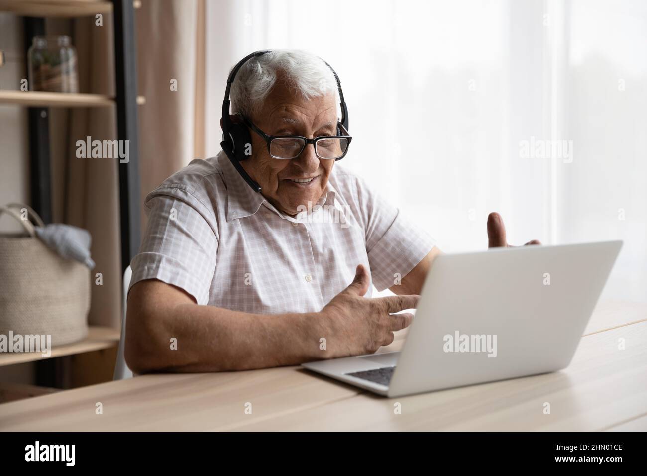 Felice uomo di 80s anni che parla con la famiglia in videochiamata Foto Stock