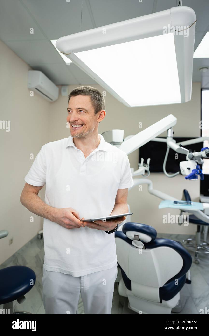 Dentista con tablet digitale in studio dentistico Foto Stock