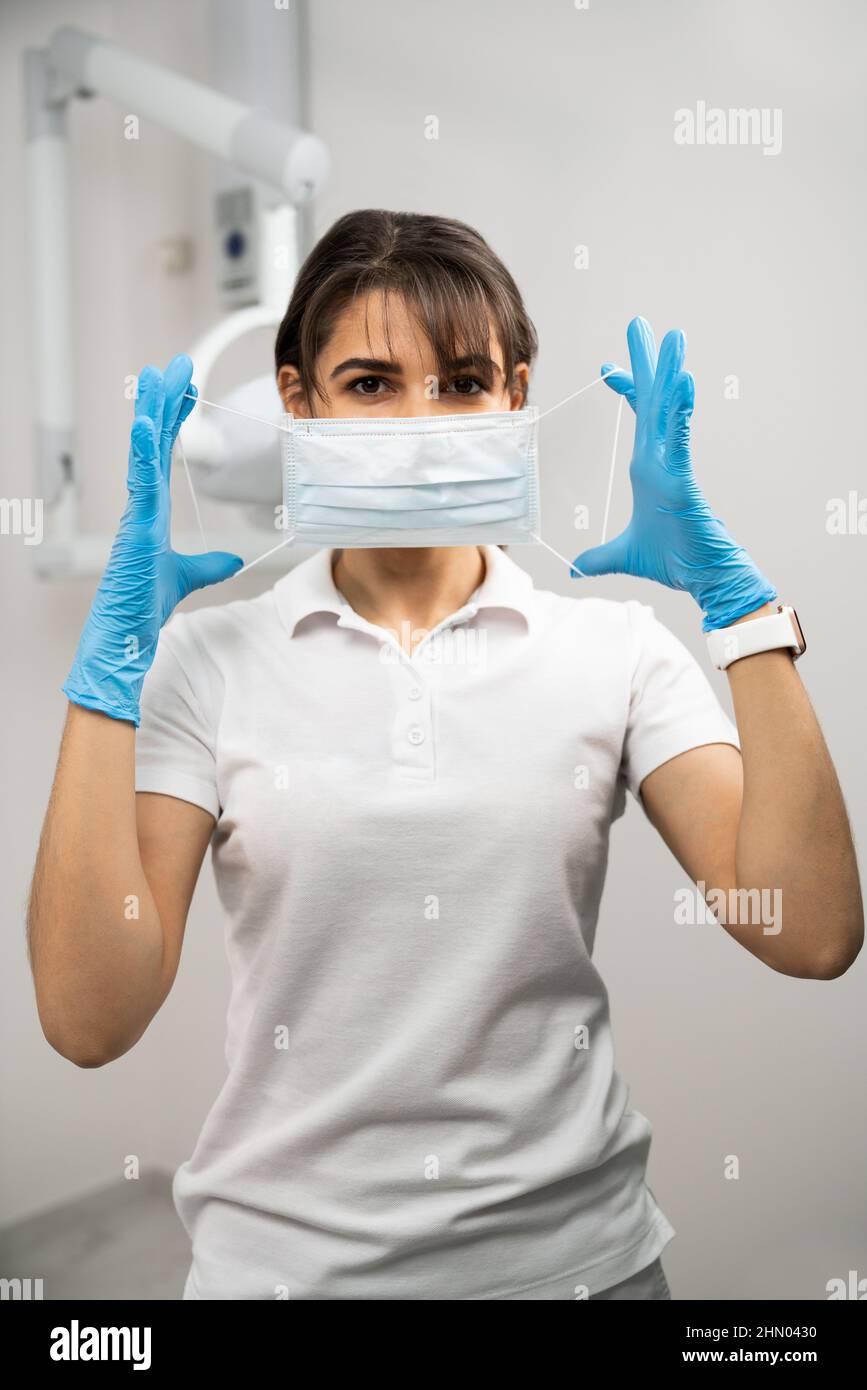 Il medico mette su una maschera medica Foto Stock
