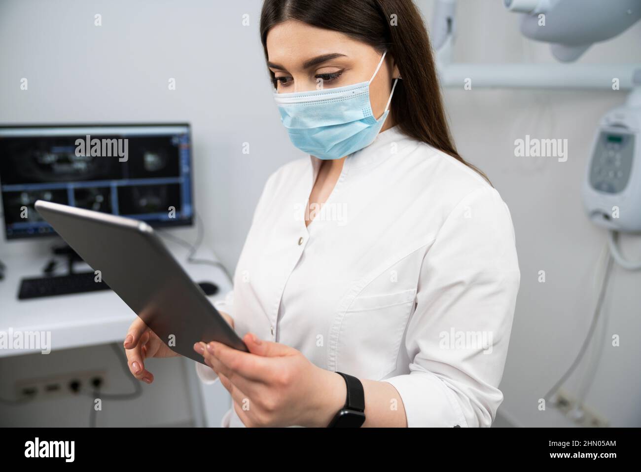 Dentista con tablet digitale in studio dentistico Foto Stock