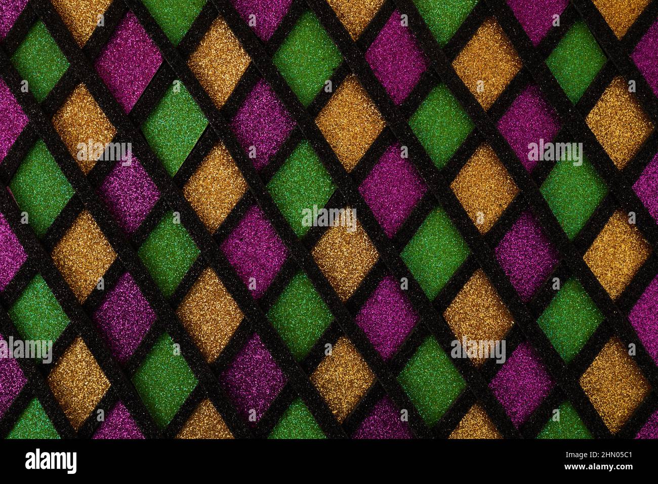 Verde lucido, viola e dorato scintillante paillettes diamanti tessuto. Mardi Gras sfondo vacanza. Foto Stock