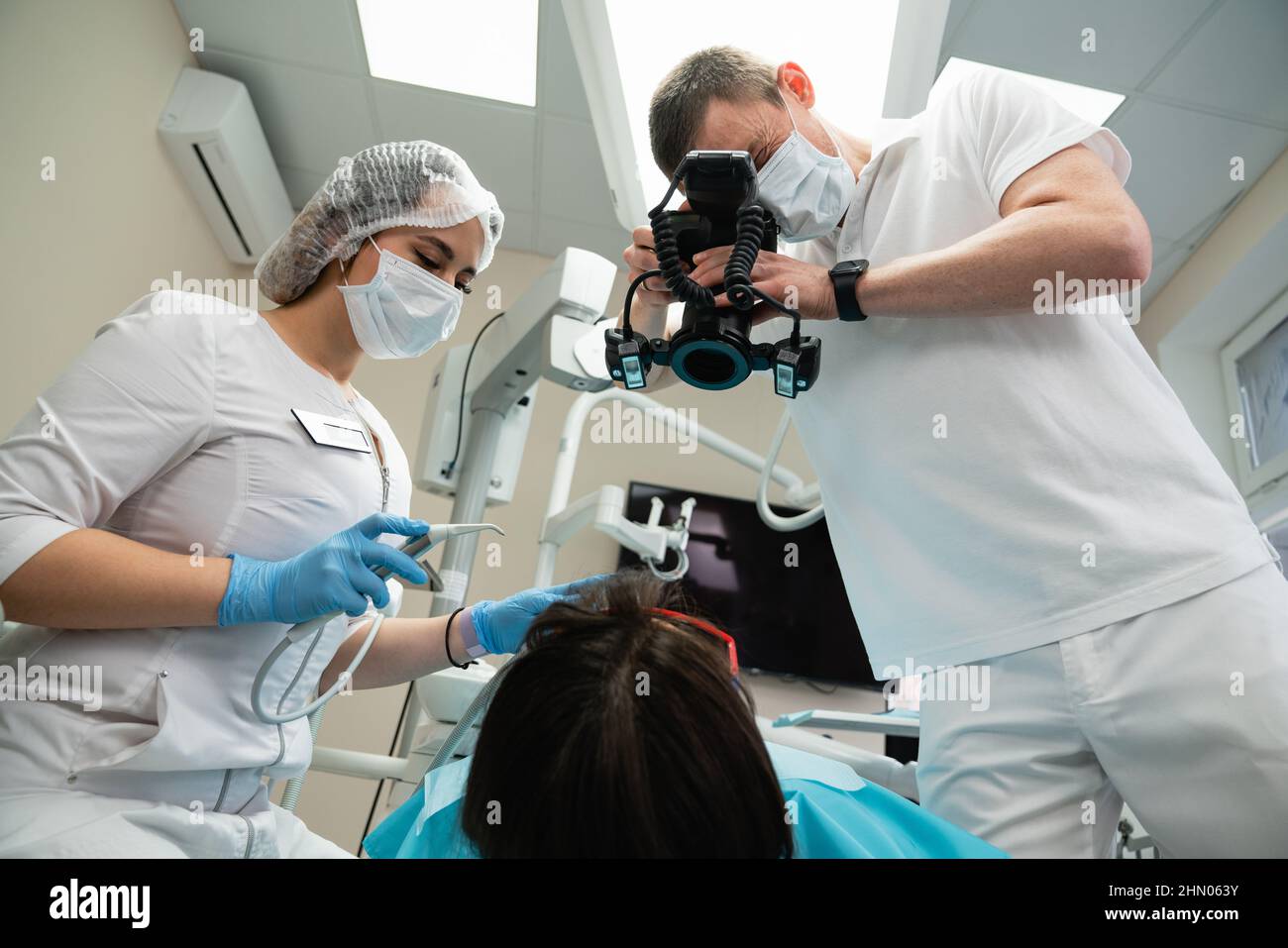 Il dentista utilizza una fotocamera per esaminare un paziente Foto Stock