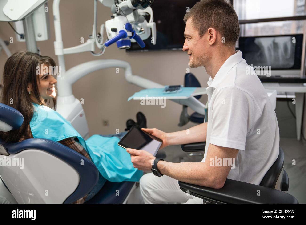 Il dentista comunica con il paziente negli studi dentistici utilizzando un tablet digitale Foto Stock
