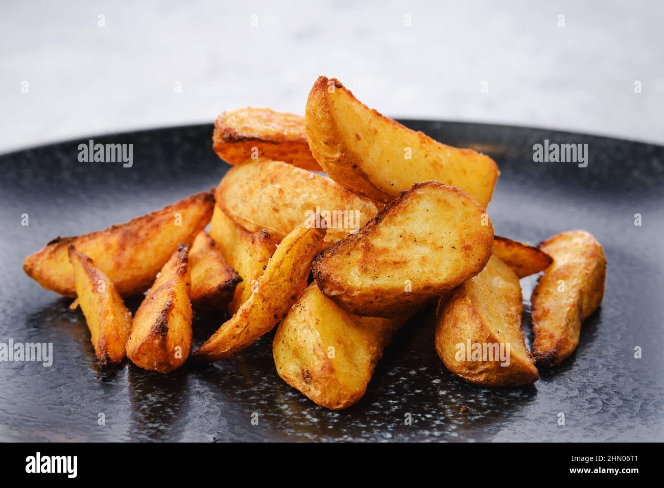 Guarnire al piatto principale - fette di patate fritte in olio, vista dal primo piano Foto Stock