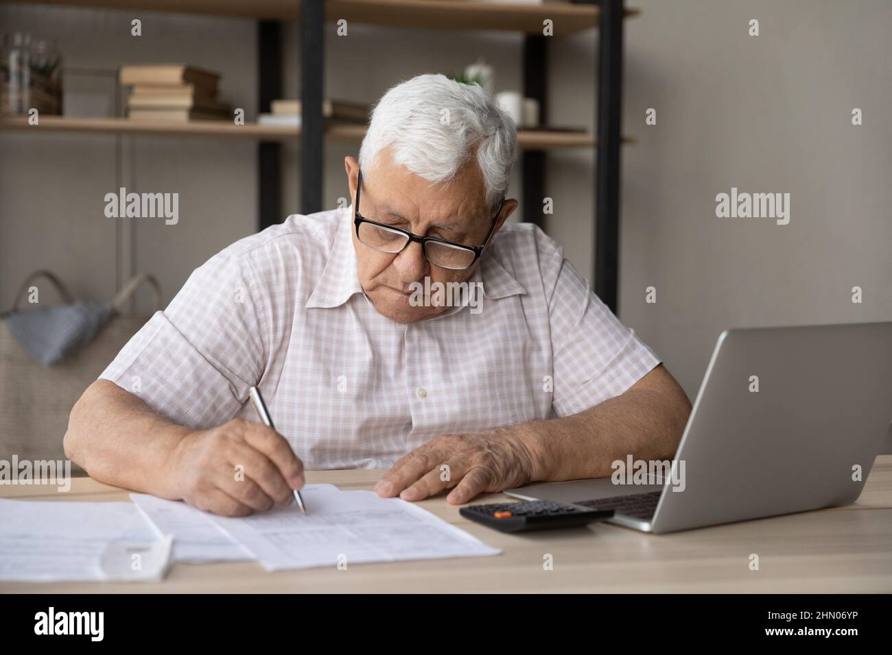 Più vecchio 80s padrone di casa, inquilino che controlla le fatture domestiche della carta Foto Stock