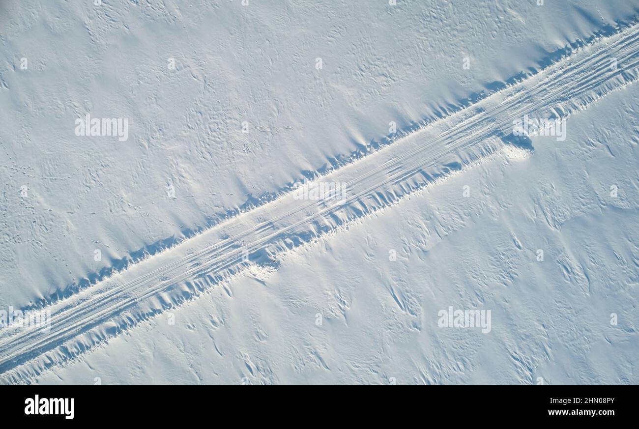 Percorso stradale in campo di neve sfondo antenna sopra la vista del drone superiore Foto Stock