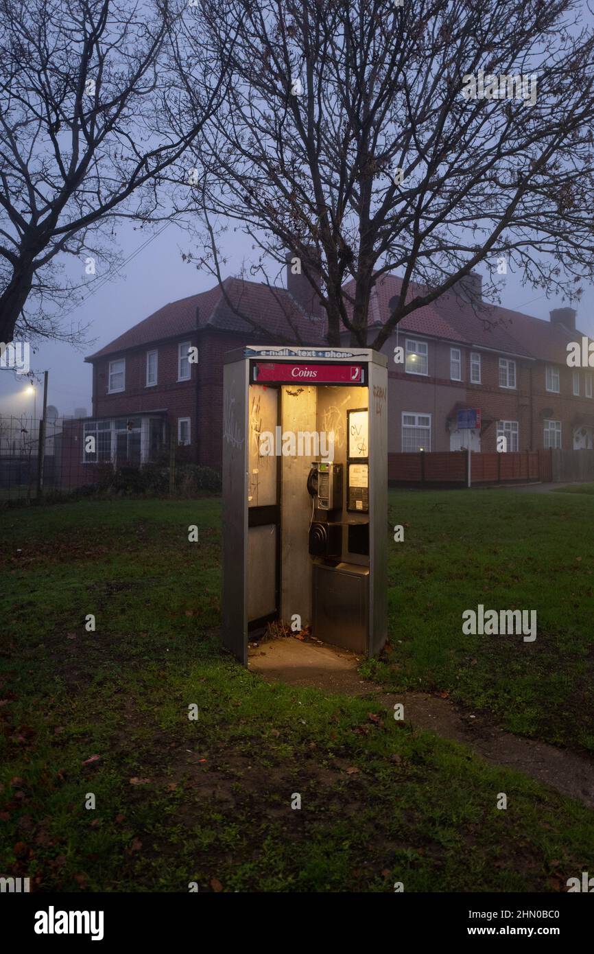 Telefono pubblico British Telecom. Foto scattata presto in una mattinata umida e nebulosa a Burnt Oak, Londra, Regno Unito Foto Stock