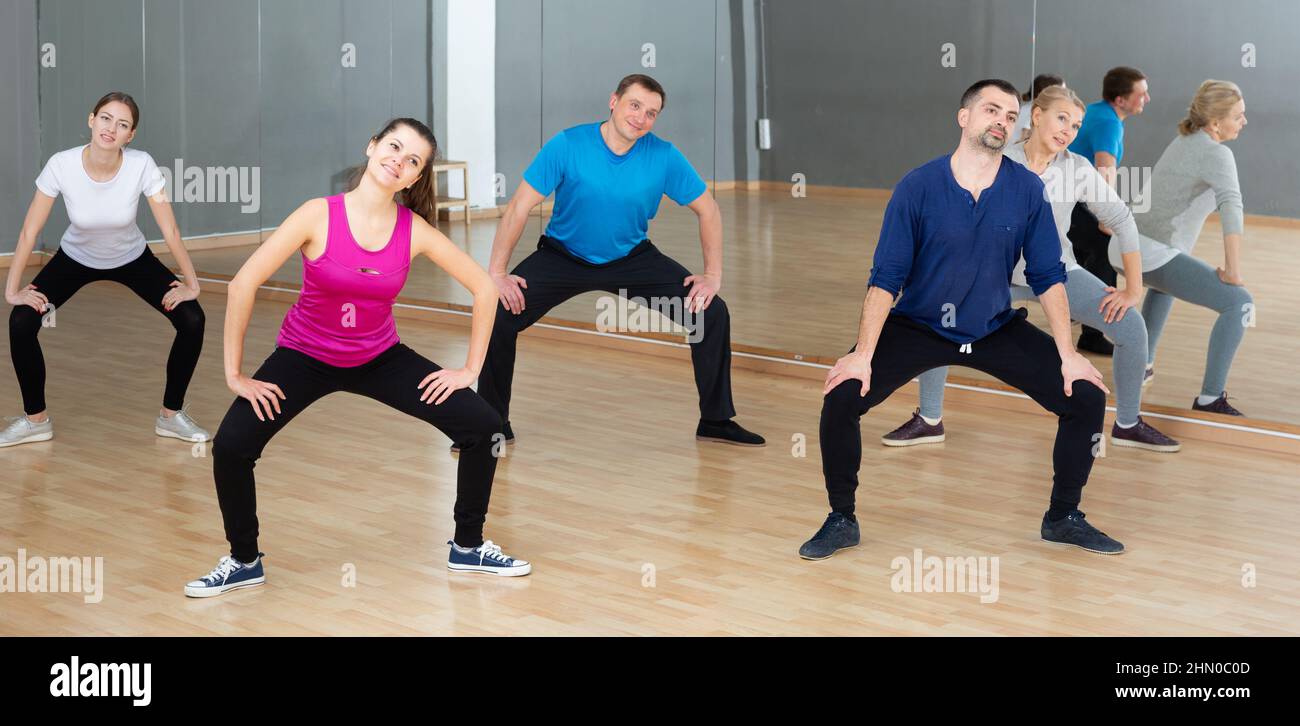 Donne e uomini che si riscaldano durante la lezione di danza Foto Stock